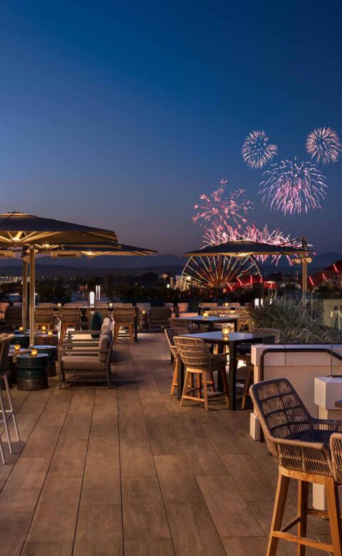 rooftop lounge in the evening with fireworks in the distance